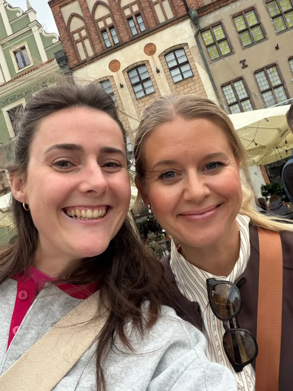 To smilende kolleger tar en selfie i gamlebyen